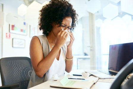 lady with a cold working from home to prevent spreading